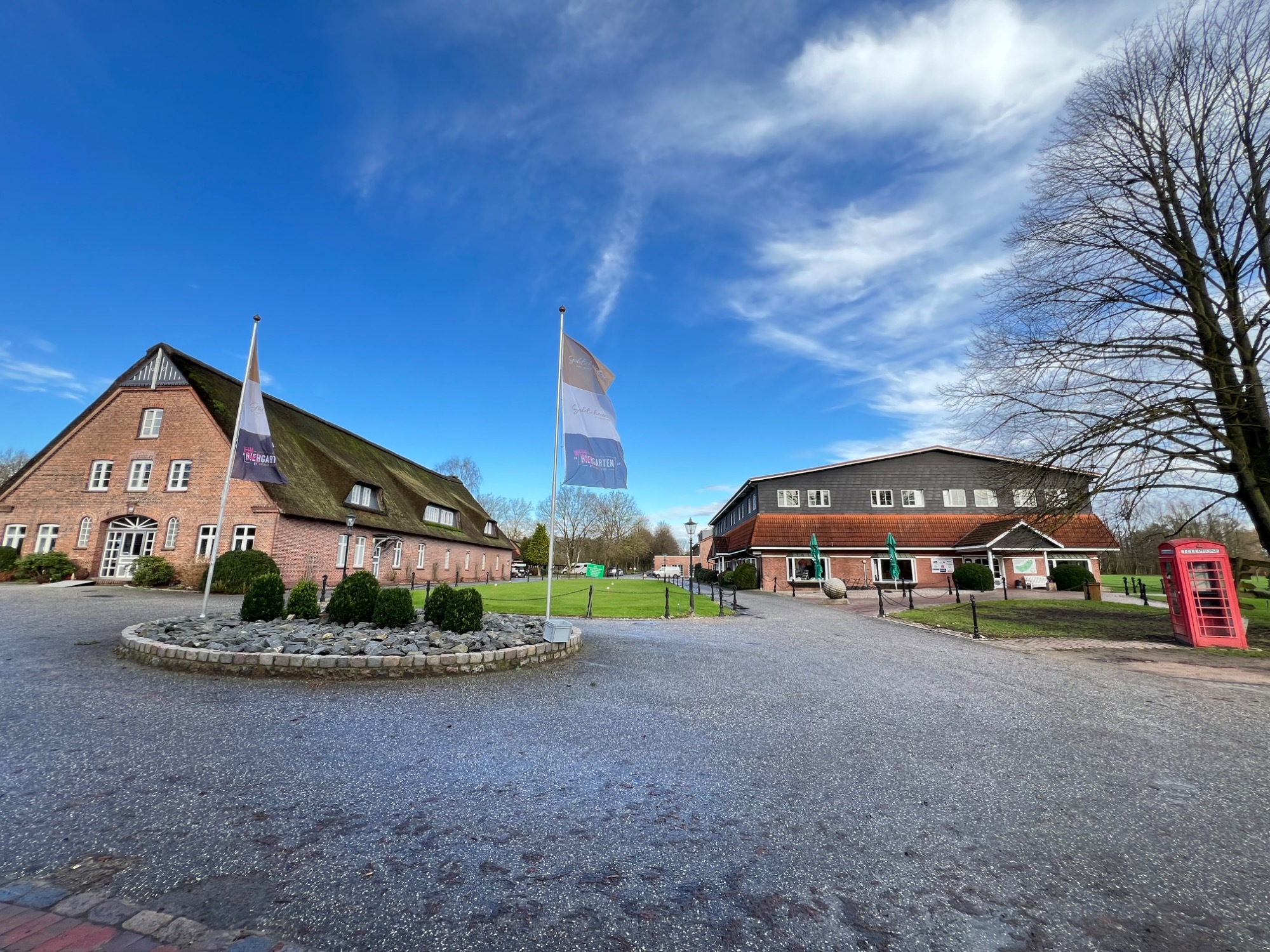 Peiner Hof courtyard with brick buildings and flags under a blue sky